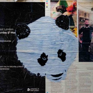 London Streetart Graffiti. Es zeigt das Bild eines Panda Kopfes in den Farben Schwarz und Weiß. Rechts im Hintergrund ist ein Zeitungsausschnitt mit dem Bild eines Mannes, Sushi auf einem grünen Blatt und einem Textteil mit schwarzer Schrift auf weißem Hintergrund. Links ist der Hintergrund Schwarz mit weißer Schrift. Der gesamte Hintergrund ist Teil einer Londoner Zeitung.
