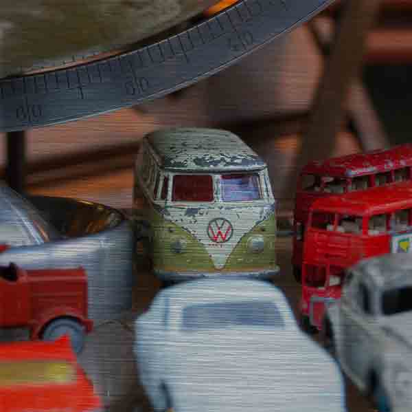 Schottland Edinburgh. Es zeigt das Bild, fotografiert in einem Antiquitätenshop, von verschiedenen historischen Spielzeugautos, darunter 2 London Bus, 1 VW Bus, 1 VW Käfer und 3 weiteren Oldtimer Autos, diese stehen unter einem Globus, von dem nur der untere Teil zu sehen ist. Das Bild ist quadratisch und in Farbe.